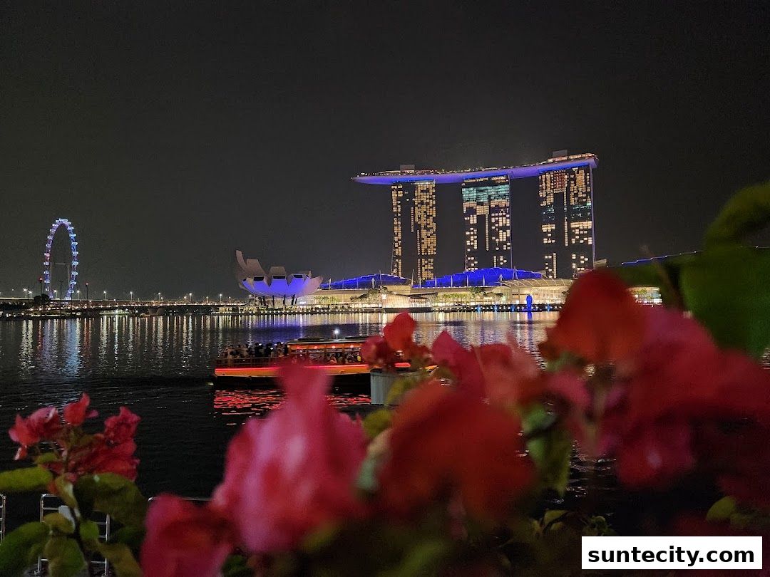 Night view of Singapore skyline with Marina Bay Sands, Singapore Flyer, and a boat.