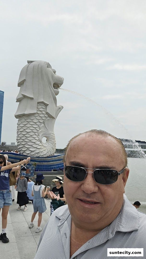 A man takes a selfie in front of the iconic Merlion statue in Singapore.