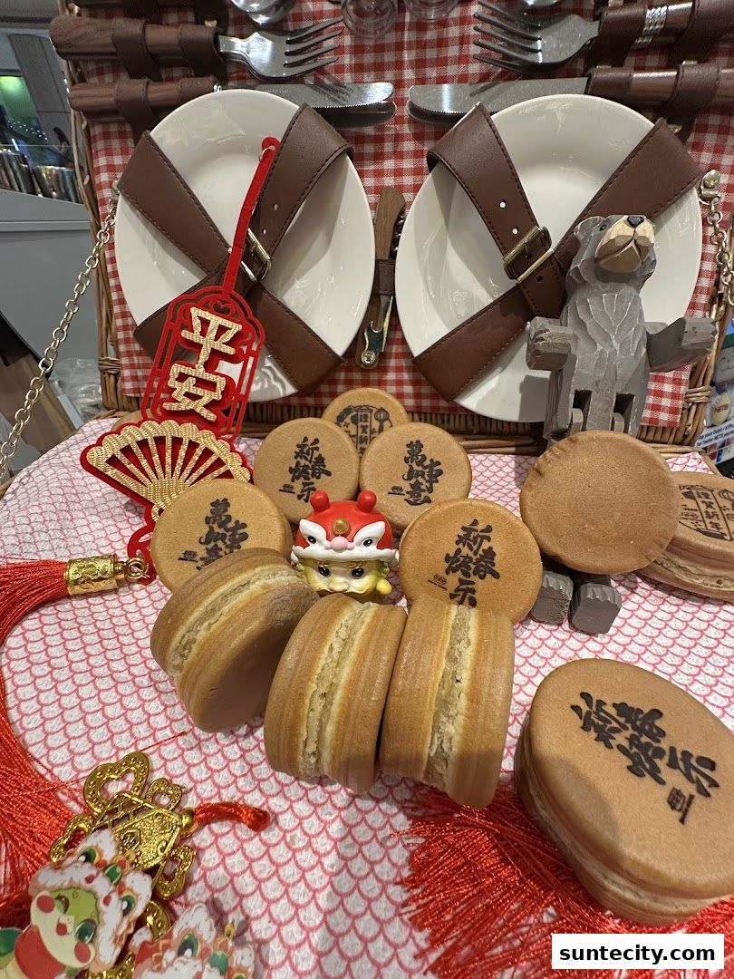 A picnic basket filled with wheel cakes, festive decorations, and a wooden bear figurine.