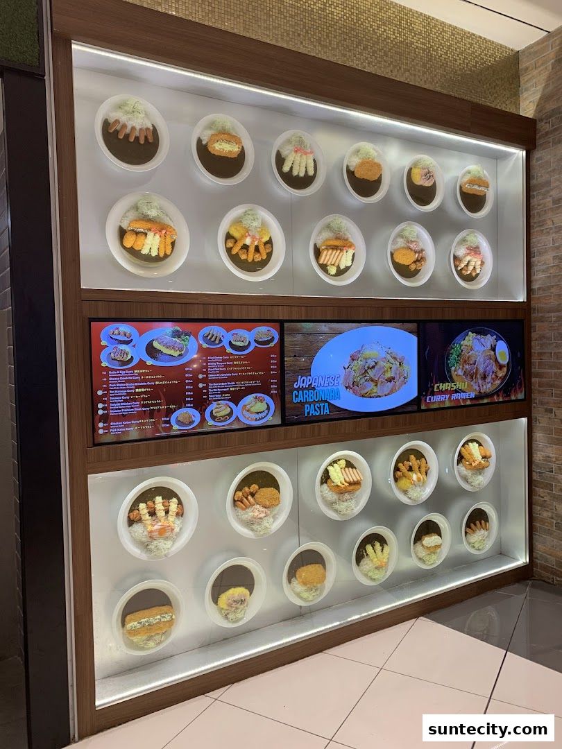 A display case showcasing realistic food models of Japanese curry dishes and other menu items.