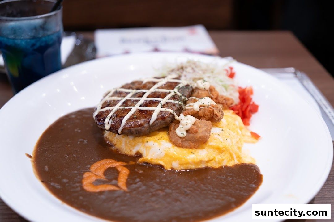 A delicious plate of Japanese curry with a hamburger steak, fried chicken, and omelet rice.