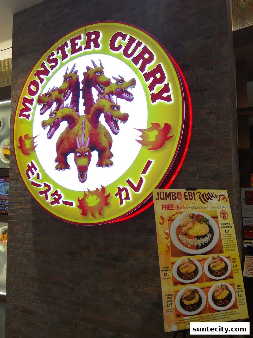 The Monster Curry shop sign with a multi-headed dragon and a menu stand.