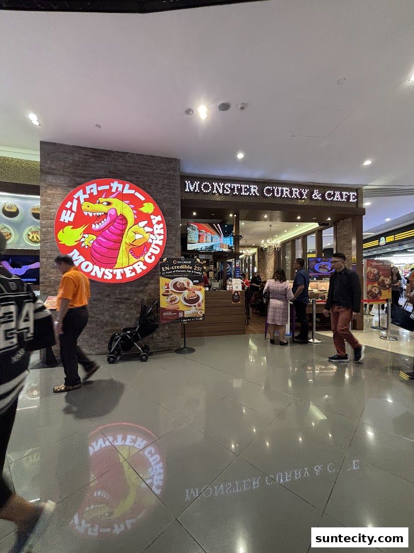 The exterior of Monster Curry & Cafe with its distinctive logo and signage.