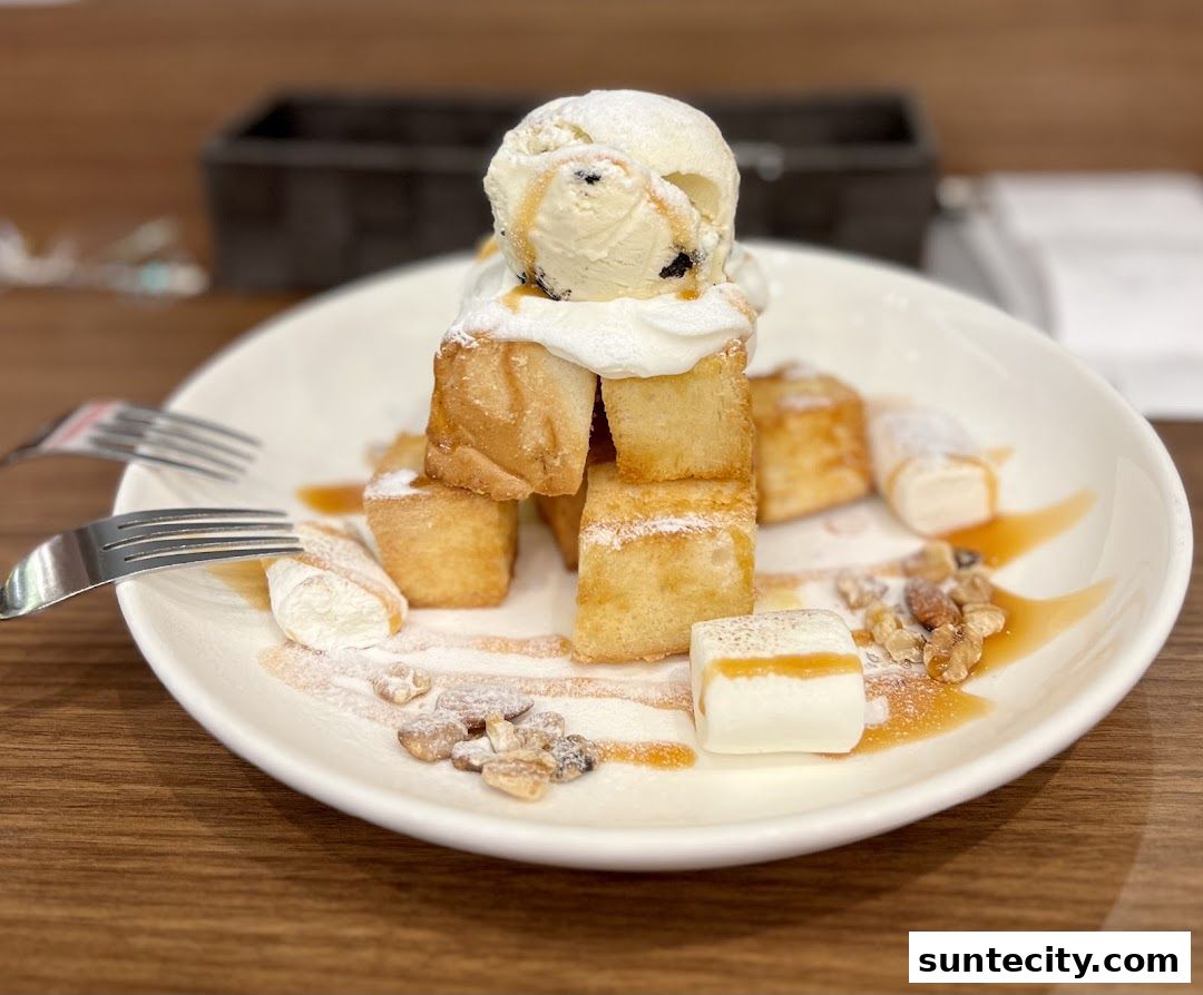 A delicious dessert featuring honey toast, ice cream, whipped cream, marshmallows, and nuts.