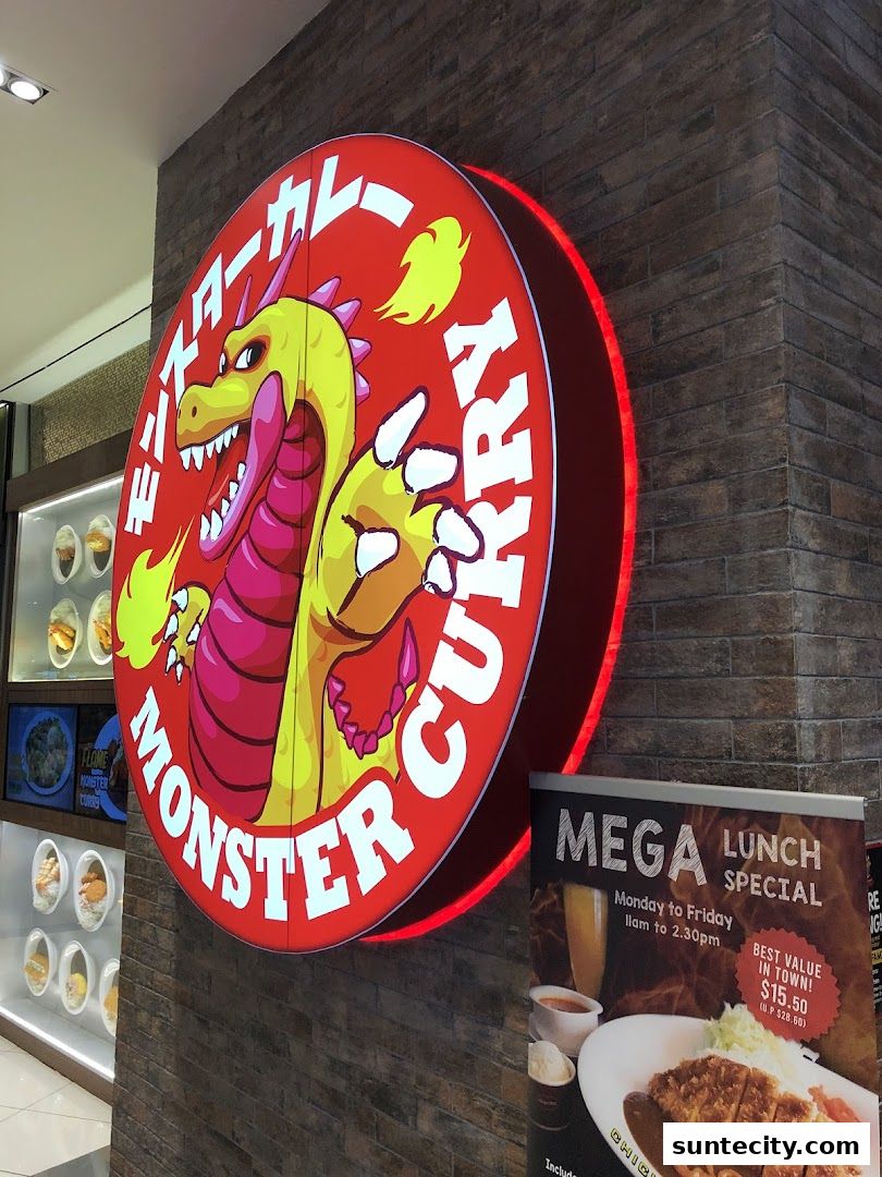 The Monster Curry shop front features a large, illuminated circular sign with a dragon mascot and the shop's name.