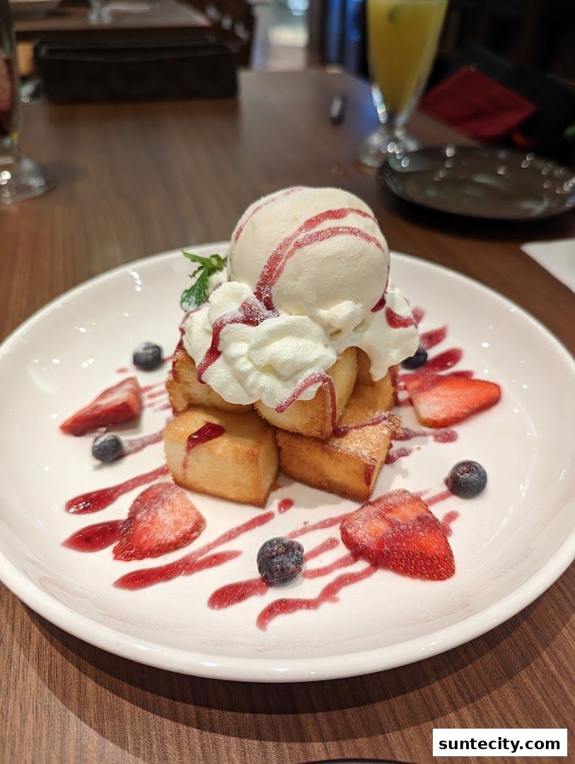 A delicious dessert with ice cream, whipped cream, toast, strawberries, and blueberries.