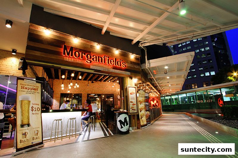 The exterior of Morganfield's restaurant with a bar and seating visible inside.