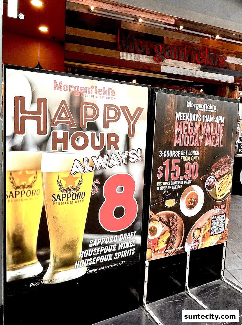 Two promotional signs outside Morganfield's restaurant, one for happy hour and another for a midday meal.
