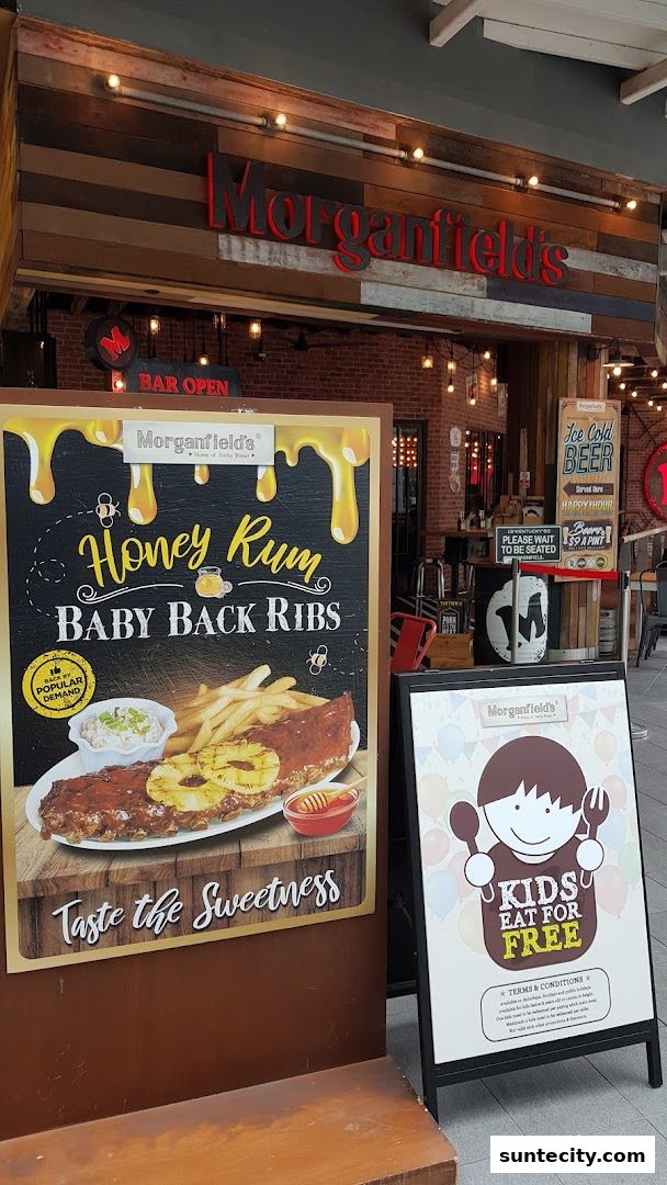 Morganfield's restaurant exterior with a 'Honey Rum Baby Back Ribs' sign and a 'Kids Eat for Free' promotion.