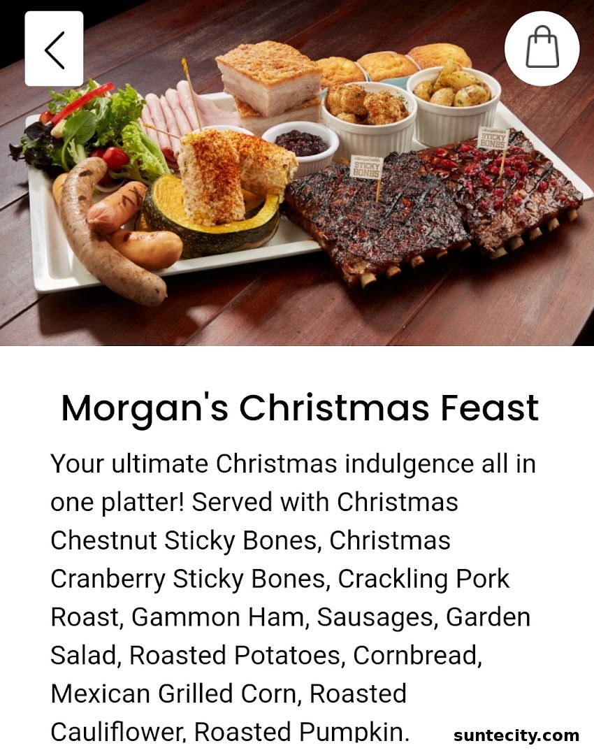 A festive platter featuring ribs, sausages, pork roast, ham, and various sides.