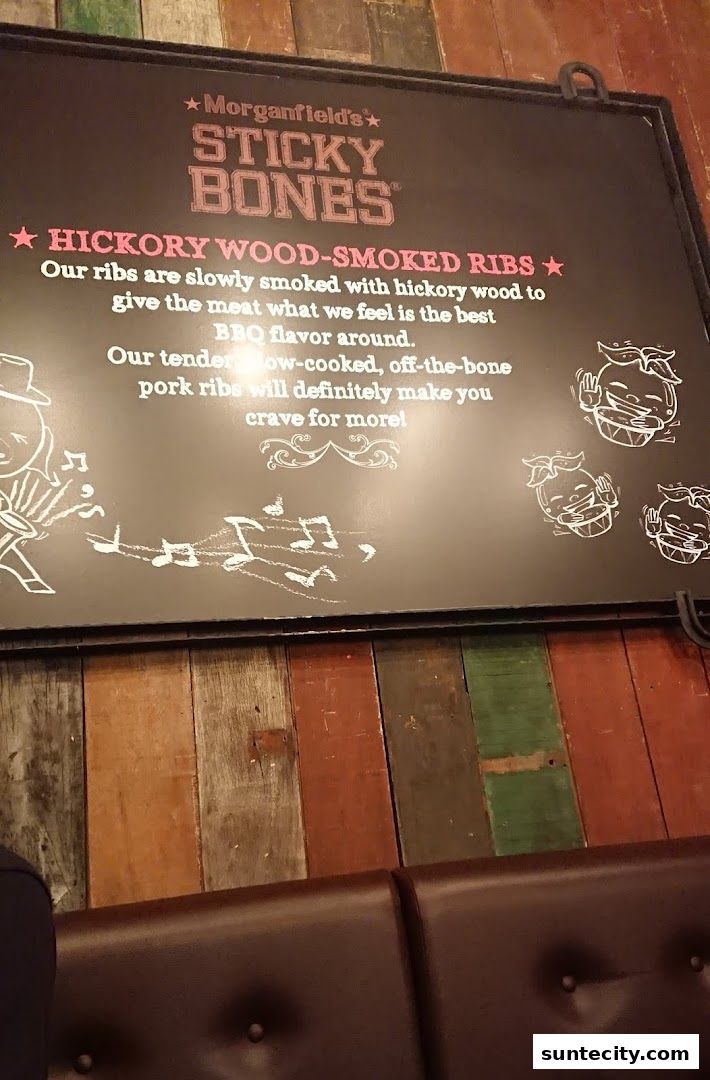 A sign advertising Morganfield's Sticky Bones hickory wood-smoked ribs.
