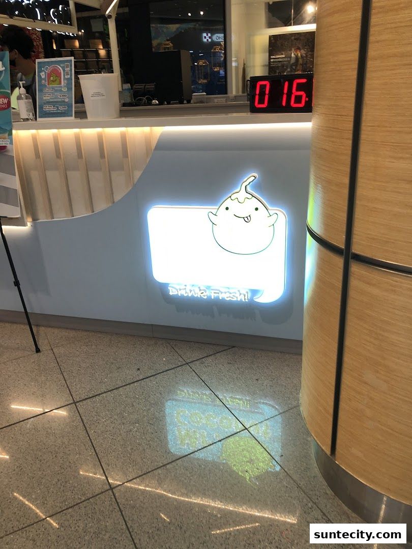 The counter area of Mr. Coconut Suntec City with a glowing sign and a digital timer.