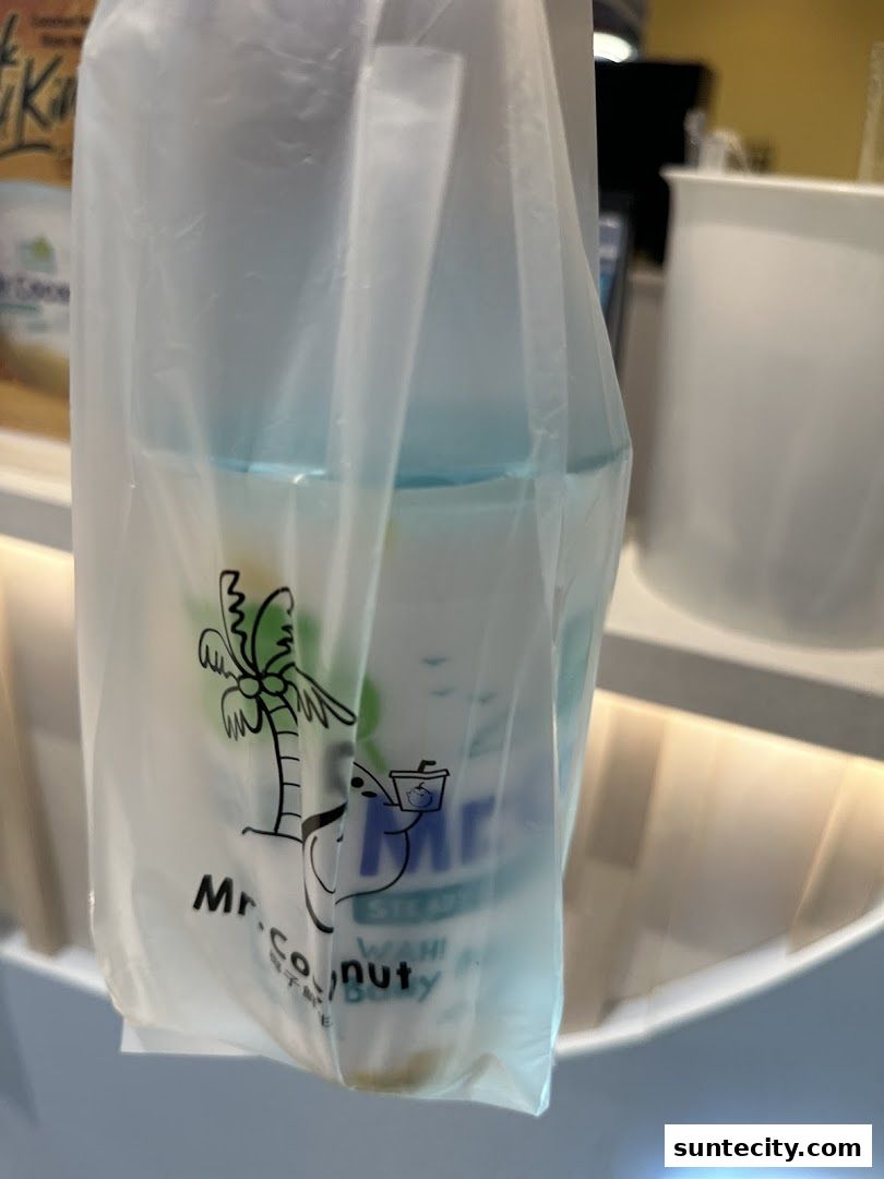A plastic bag from Mr. Coconut Suntec City holding a drink with the shop's logo visible.