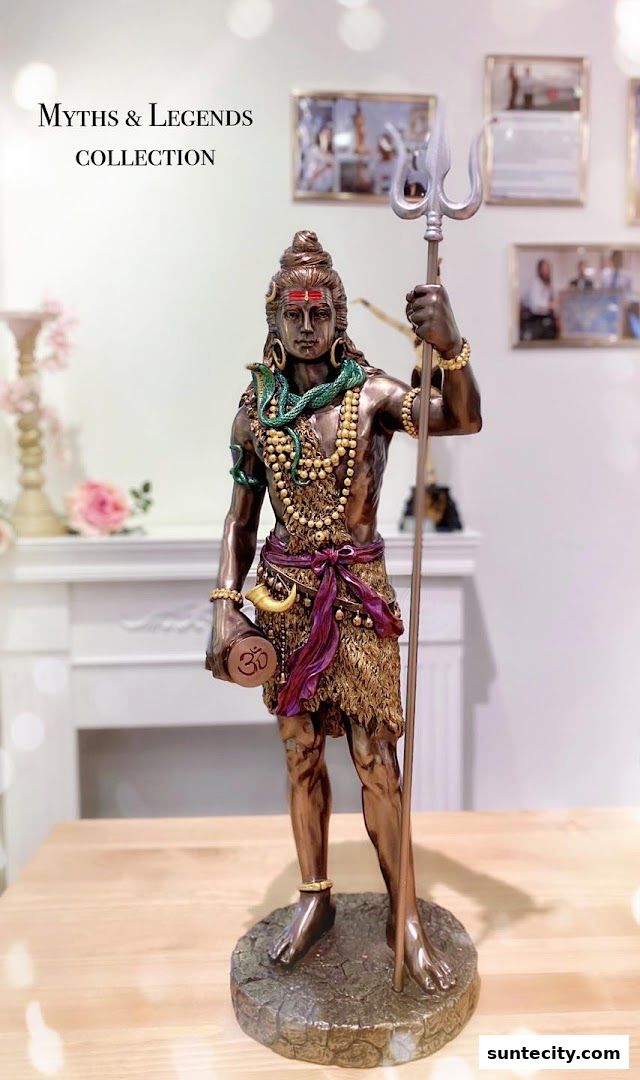 A detailed statue of Lord Shiva holding a trident and drum, adorned with snakes and beads.