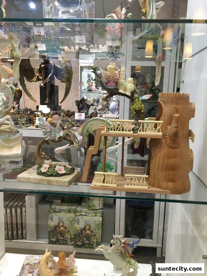 A display case filled with various fantasy figurines, including fairies, angels, and mythical creatures.