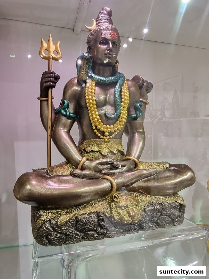 A detailed statue of Lord Shiva in a meditative pose, adorned with a snake and trident.