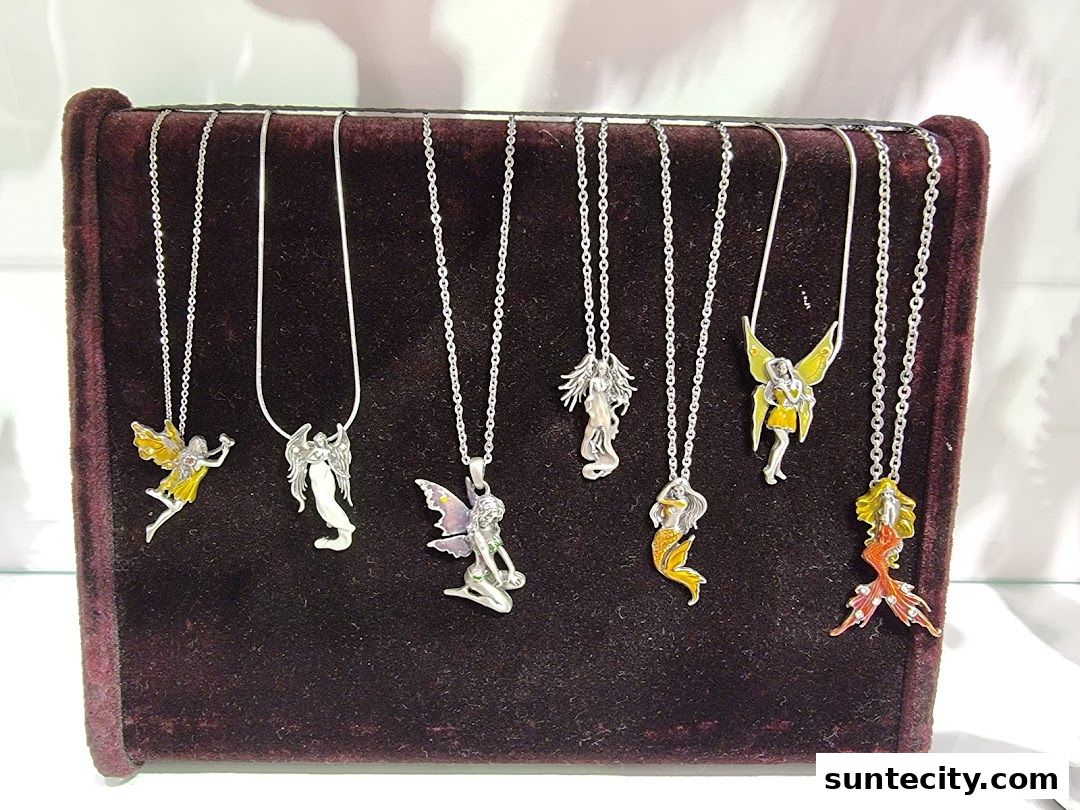 A display of various fairy and mermaid-themed necklaces on a velvet stand.