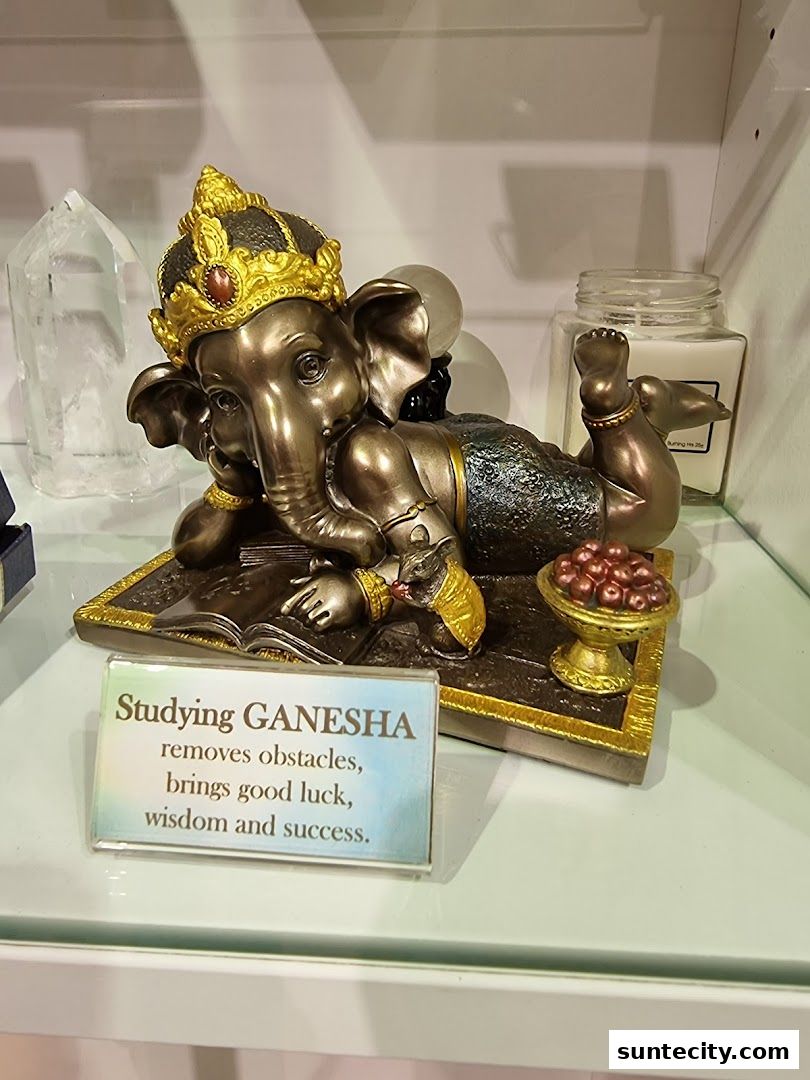 A statue of Ganesha studying, with a sign detailing its benefits.