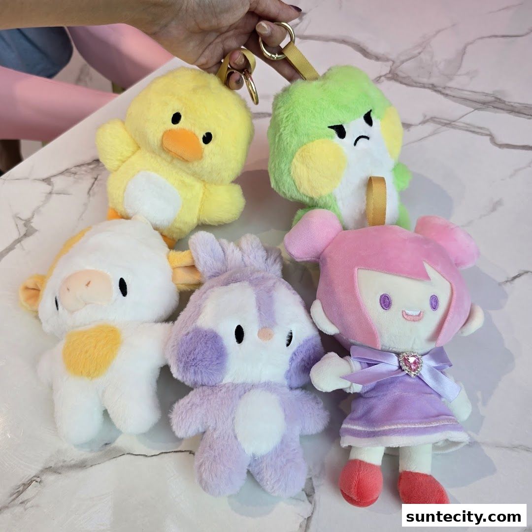 A collection of five cute, plush character keychains on a marble surface.