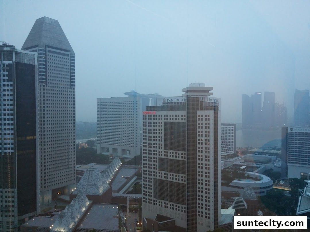 A cityscape view of tall buildings and skyscrapers under a hazy sky.