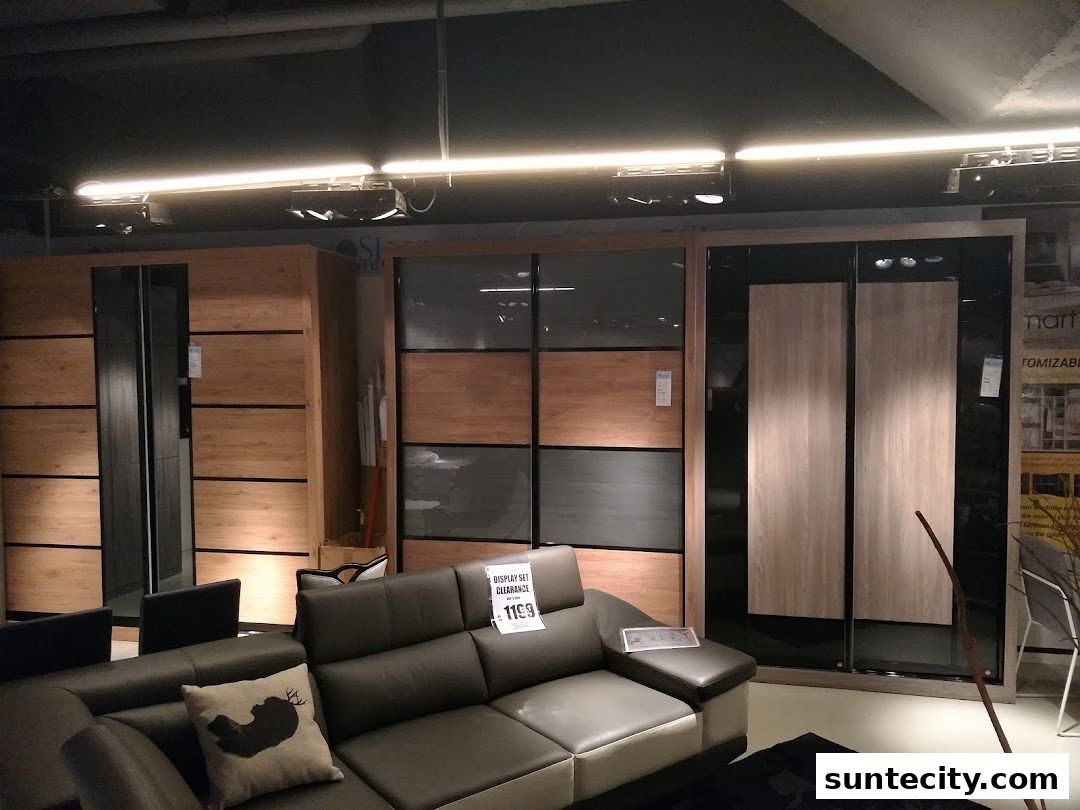 A modern furniture store interior featuring sofas and wardrobes with wood and glass finishes.