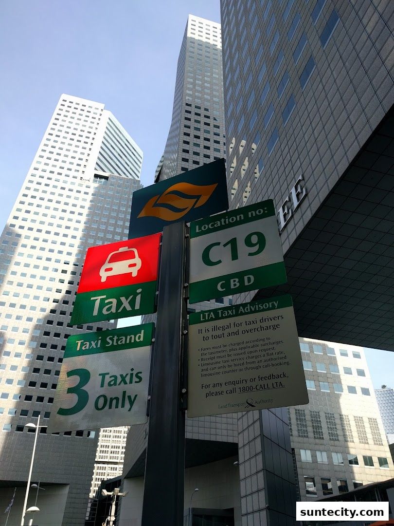 A signpost indicating a taxi stand with location and advisory information.