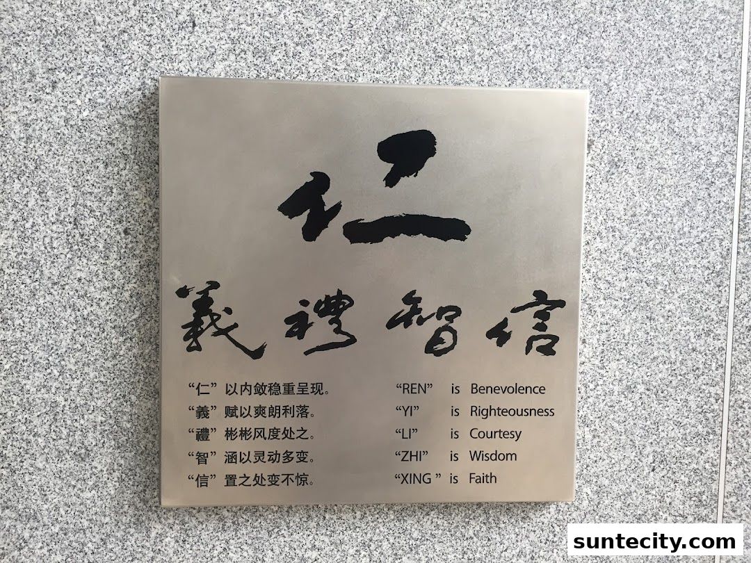 A metal plaque with Chinese calligraphy and English translations of virtues.