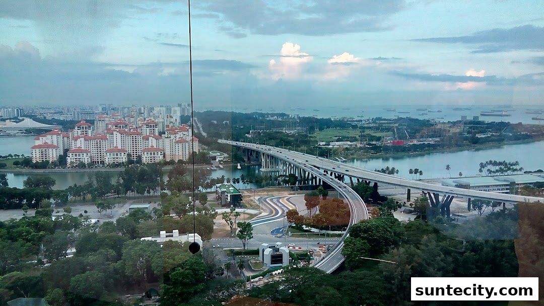 Panoramic view of a city skyline with a bridge, residential buildings, and a harbor.