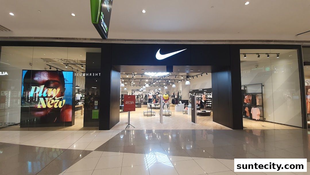 The entrance of a Nike store with its iconic logo and displays of athletic wear.