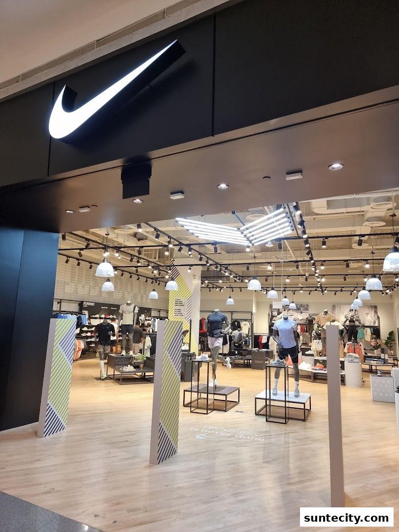 The entrance to a Nike store, showcasing mannequins in athletic wear and the iconic Nike logo.