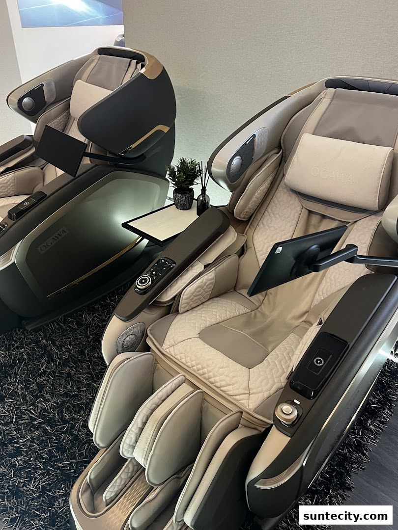 Two luxurious Ogawa massage chairs are displayed on a dark carpet.