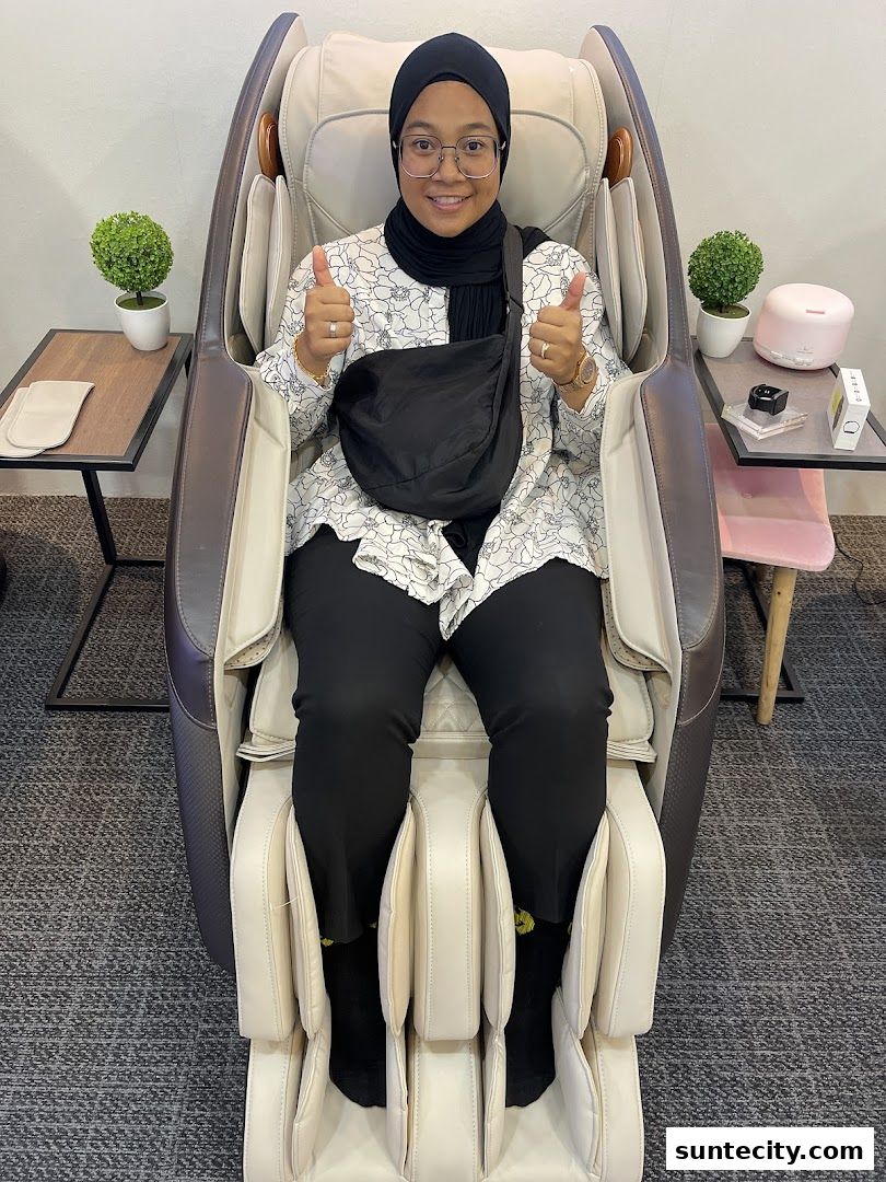 A woman sits in a massage chair, giving a thumbs up.