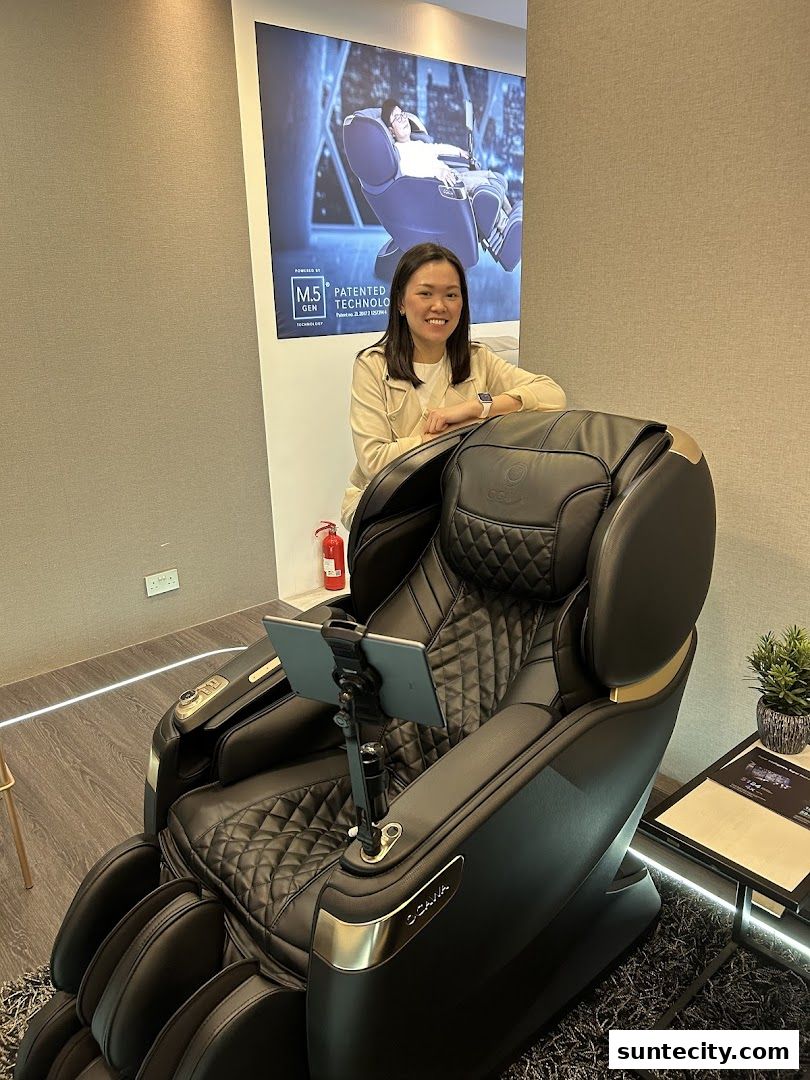 A woman smiles next to a luxurious black massage chair with a tablet attached.