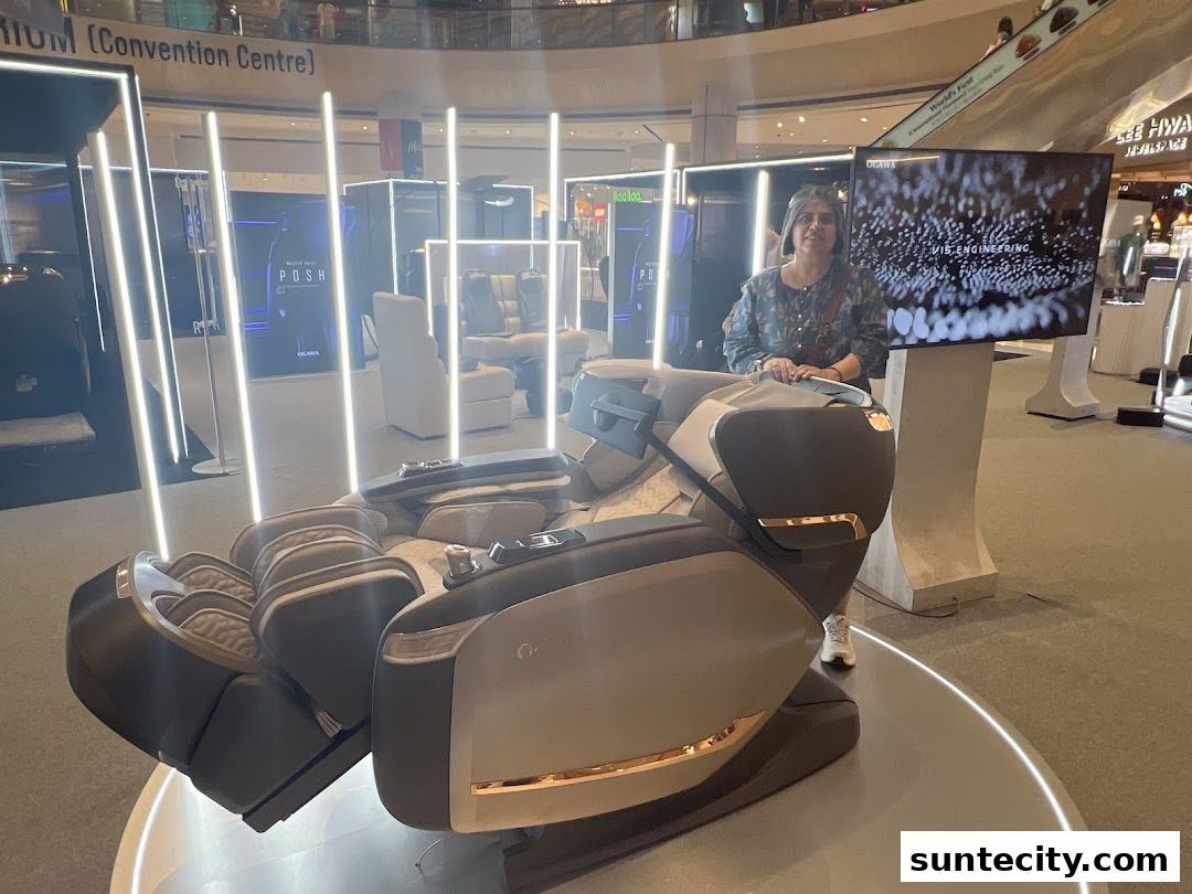A woman stands next to a luxurious massage chair at an Ogawa showroom.