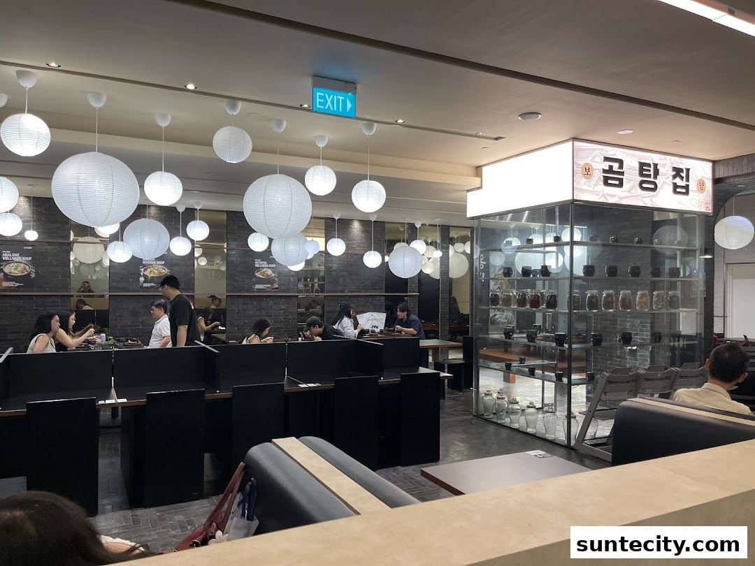 Interior of a Korean restaurant with customers dining and decorative lanterns hanging from the ceiling.