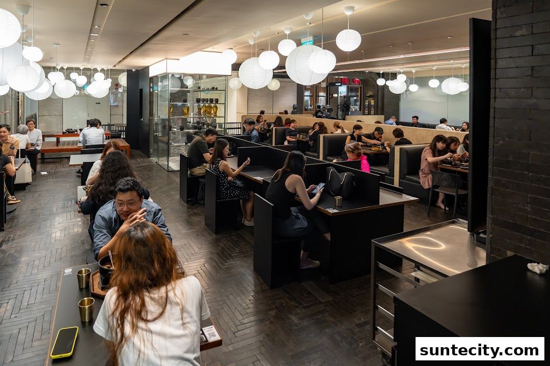 A busy restaurant interior with diners seated at individual tables and booths.
