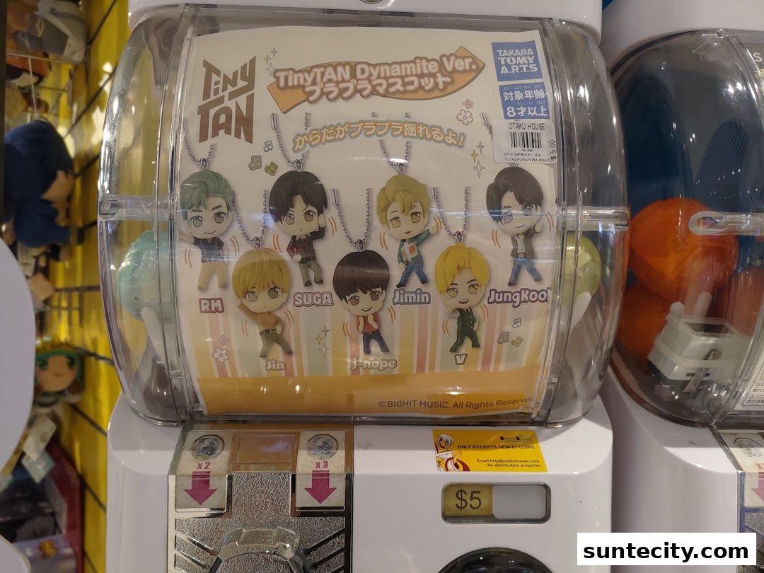 A gachapon machine featuring TinyTAN Dynamite Ver. mascots from BTS.