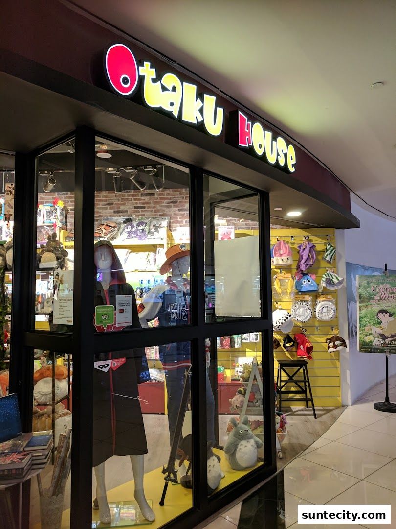The Otaku House shop front displays anime merchandise, mannequins, and plush toys in its window.