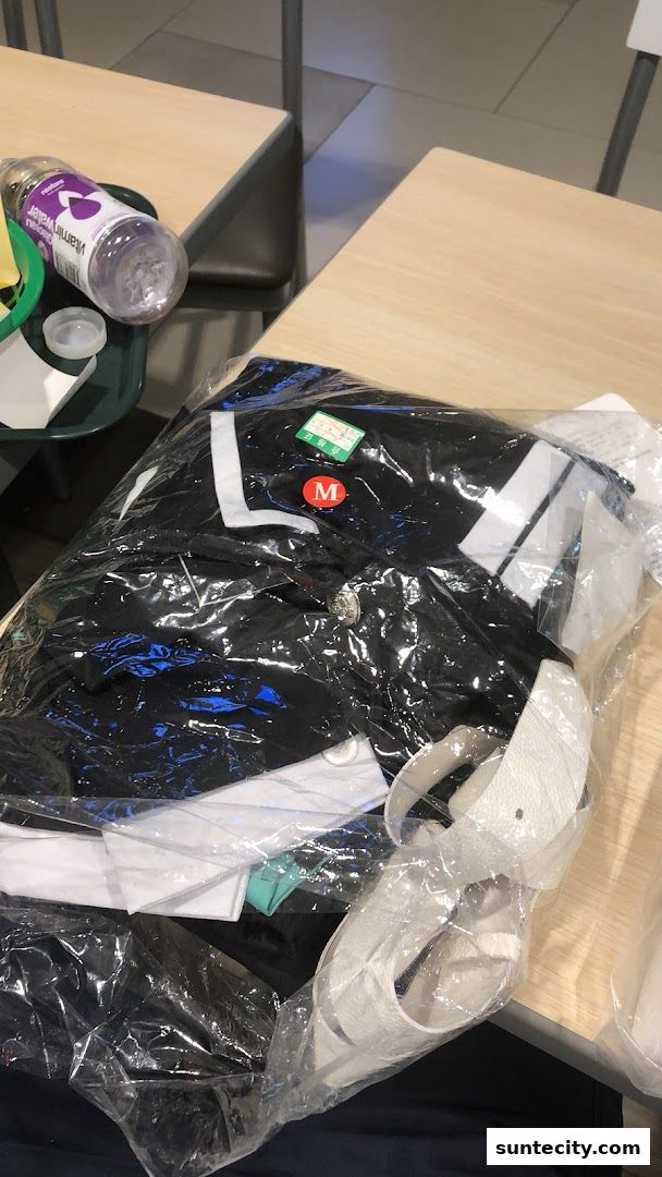 A packaged black and white outfit with a size M tag and a white belt.
