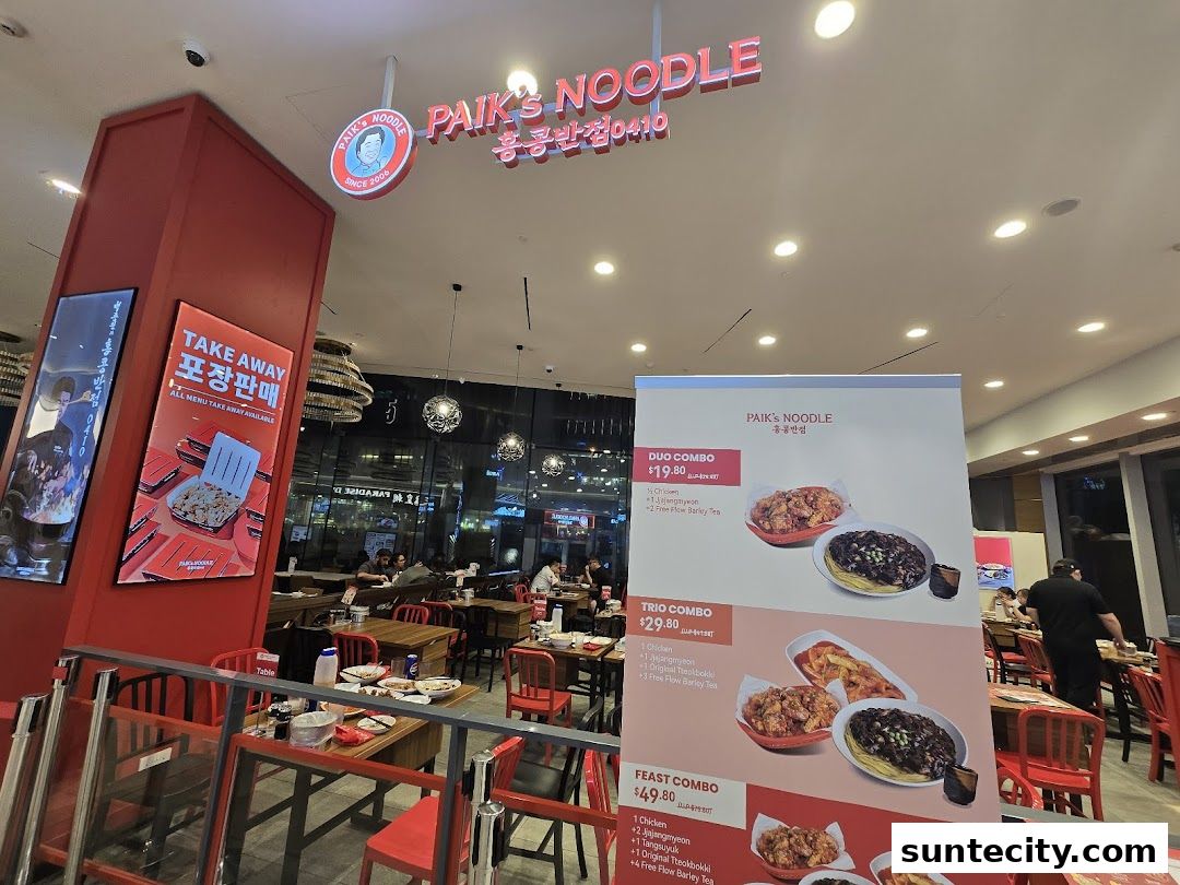 Interior of Paik's Noodle restaurant with a menu board and seating.