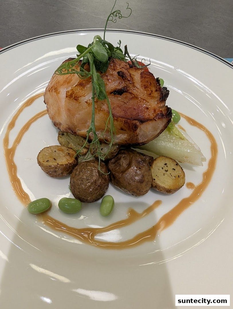 A beautifully plated dish featuring grilled meat, roasted potatoes, edamame, and greens with a drizzle of sauce.