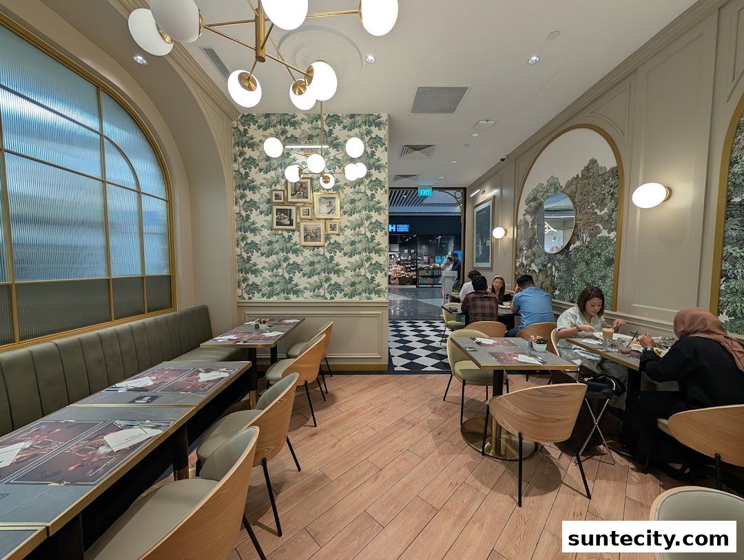 Interior of a PAUL Suntec cafe with customers dining at tables and elegant decor.