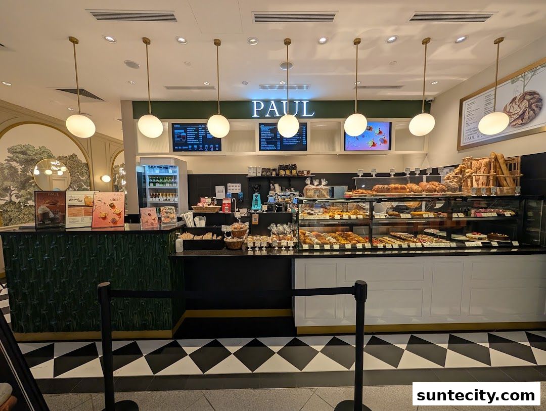 Interior view of a PAUL bakery with a display of fresh bread, pastries, and a counter.