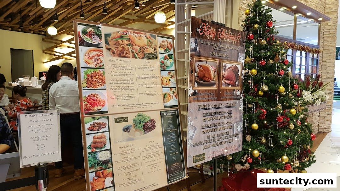 A restaurant menu board with food pictures and a Christmas tree in the foreground.