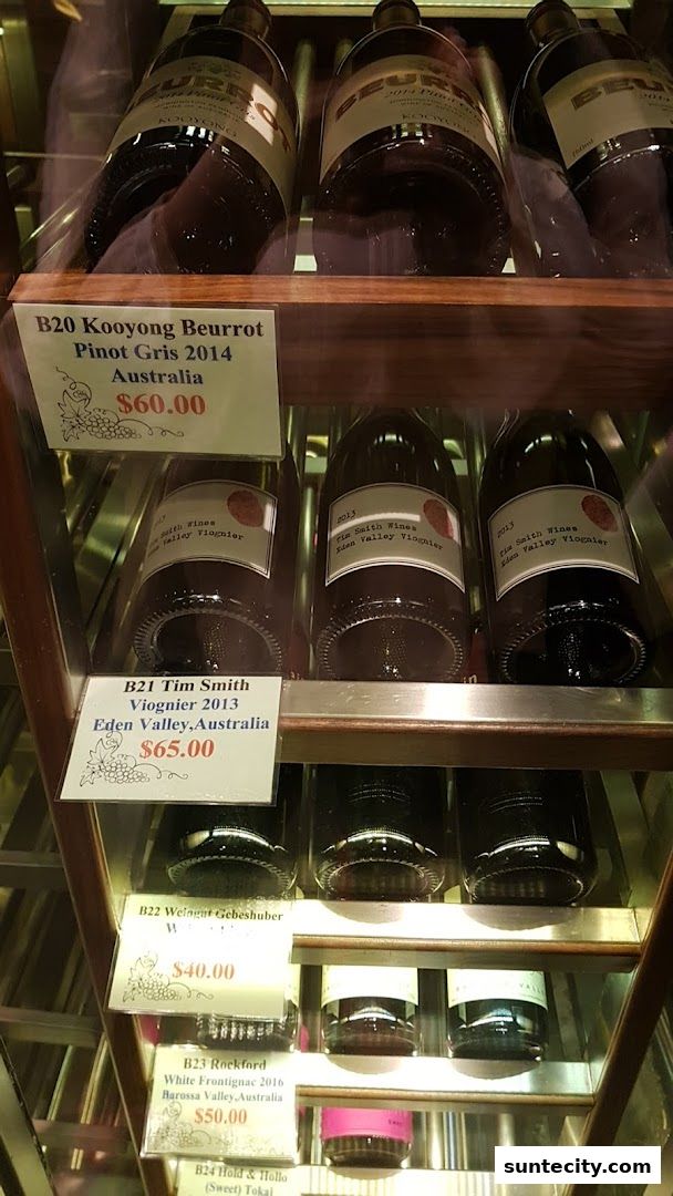 A display of various wine bottles with price tags in a retail setting.