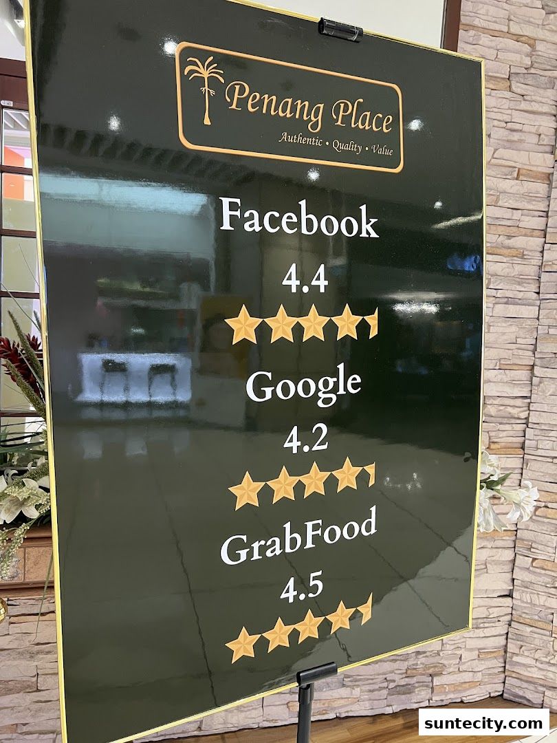 A sign displays high ratings for Penang Place from Facebook, Google, and GrabFood.