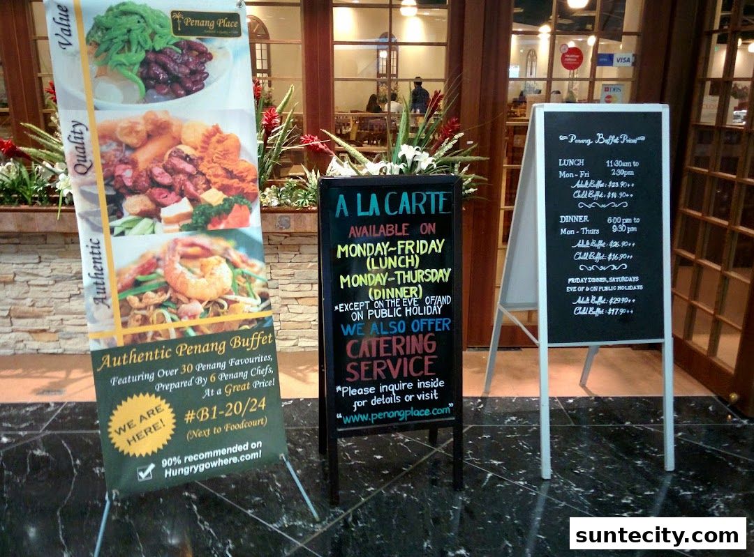 A Penang Place restaurant advertises its authentic Penang buffet and a la carte options with a prominent banner and two chalkboards.