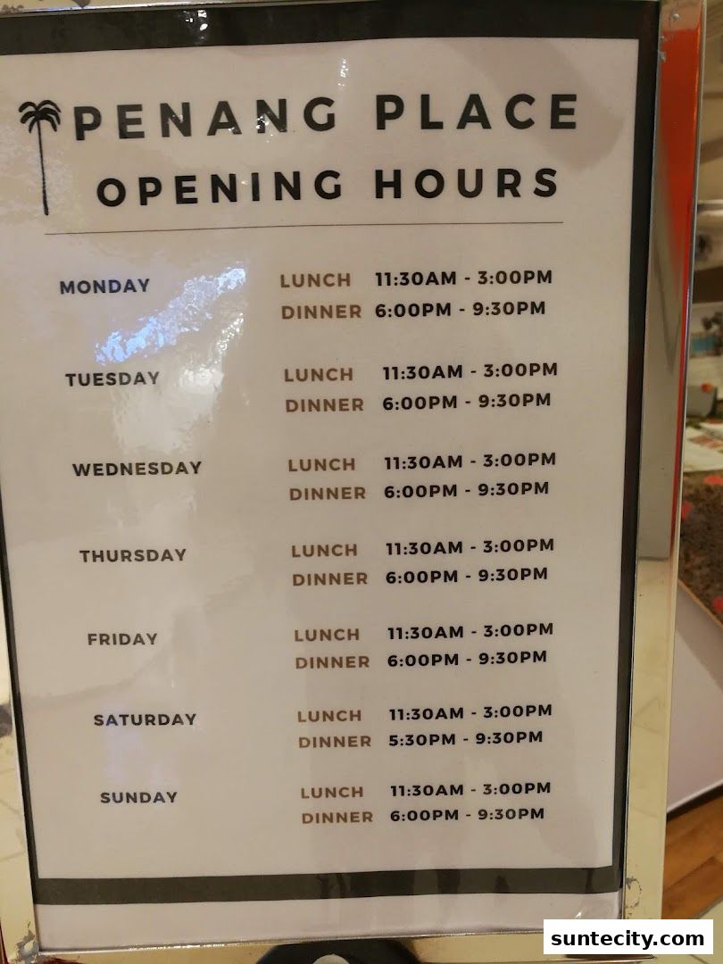 Penang Place opening hours displayed on a sign, detailing lunch and dinner times for each day.