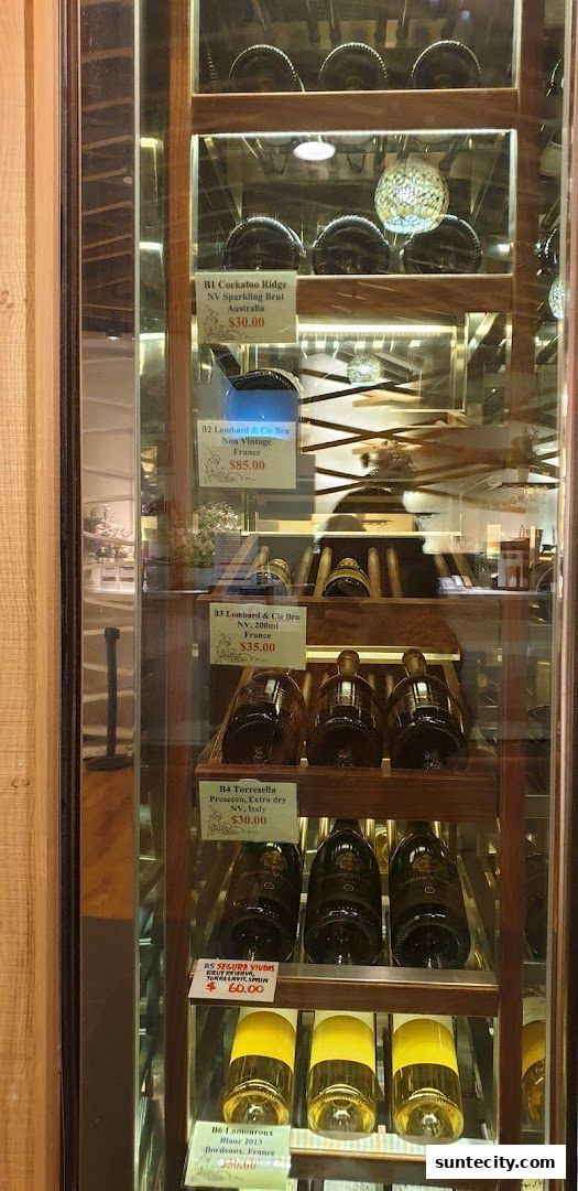 A display cabinet showcasing various bottles of wine with price tags.