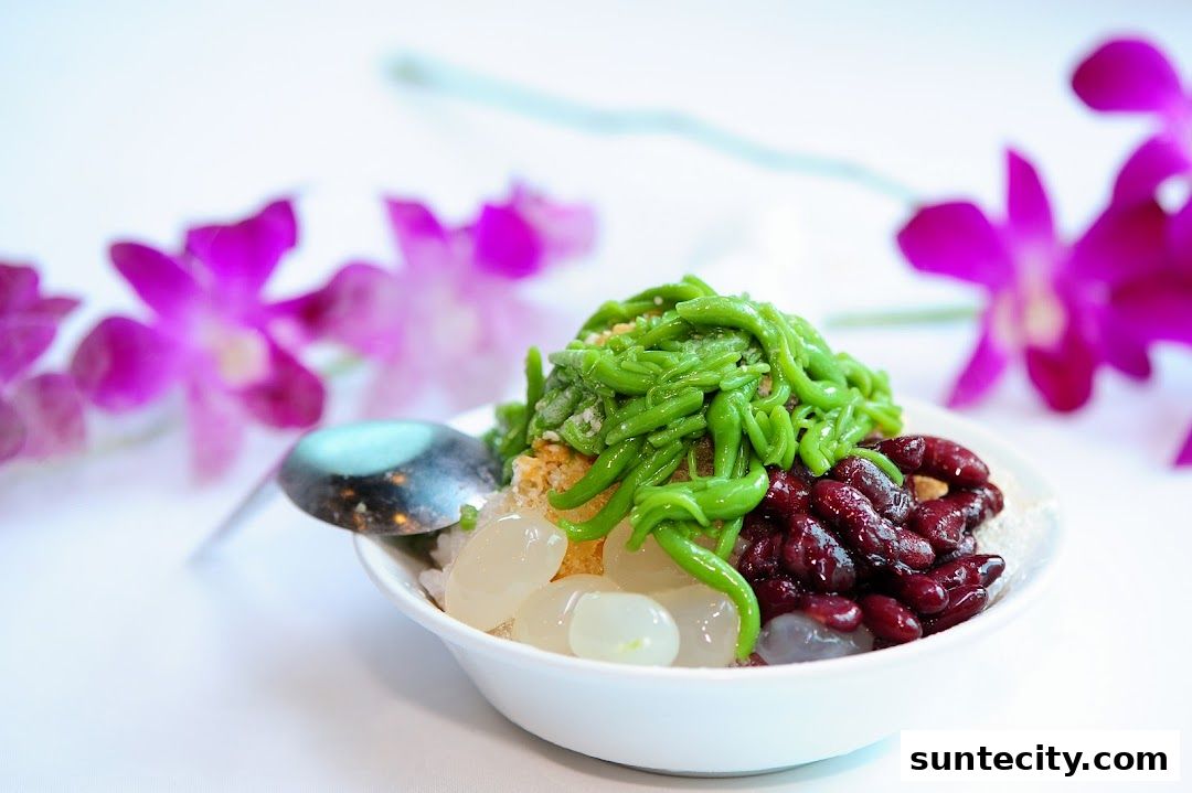 A refreshing bowl of Cendol with red beans and palm seeds, garnished with purple orchids.